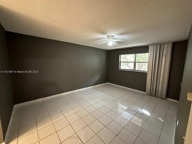 tiled spare room featuring ceiling fan and a textured ceiling