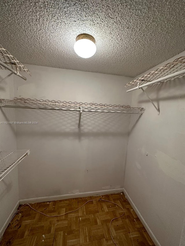 spacious closet featuring parquet floors