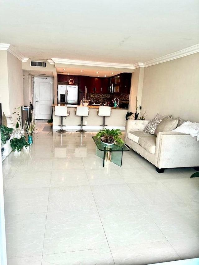 living room featuring light tile patterned floors and ornamental molding