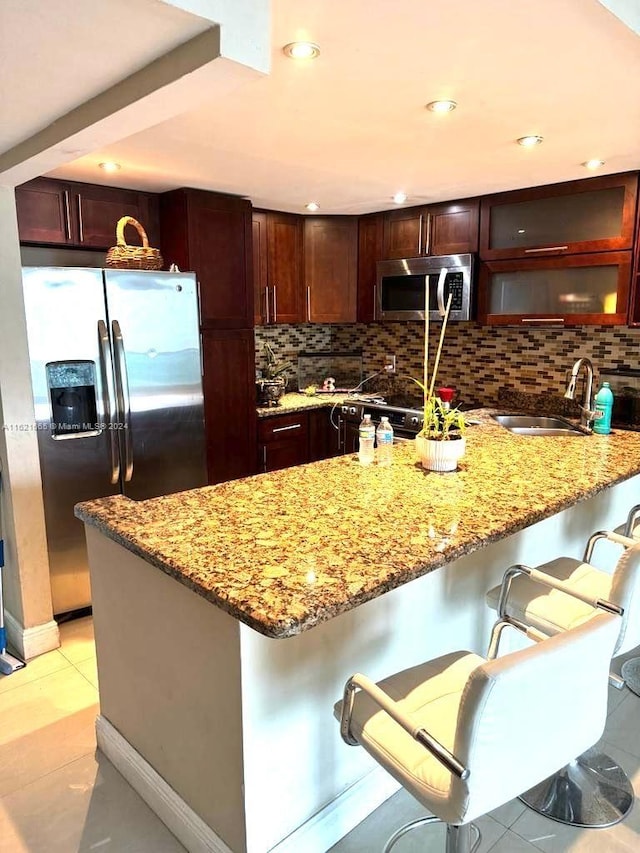 kitchen featuring sink, appliances with stainless steel finishes, backsplash, and light tile patterned floors