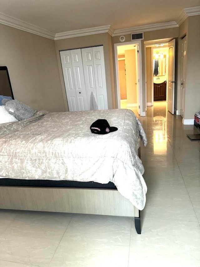 tiled bedroom with ensuite bathroom, a closet, and ornamental molding