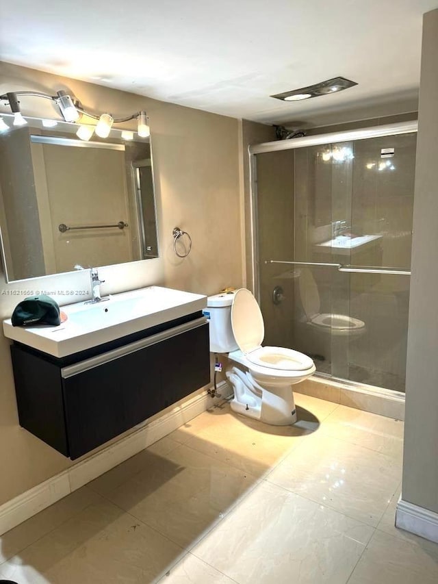 bathroom featuring vanity, walk in shower, tile patterned flooring, and toilet