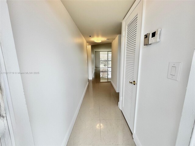 corridor with a chandelier and light tile patterned floors