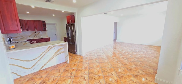 kitchen featuring stainless steel fridge and backsplash