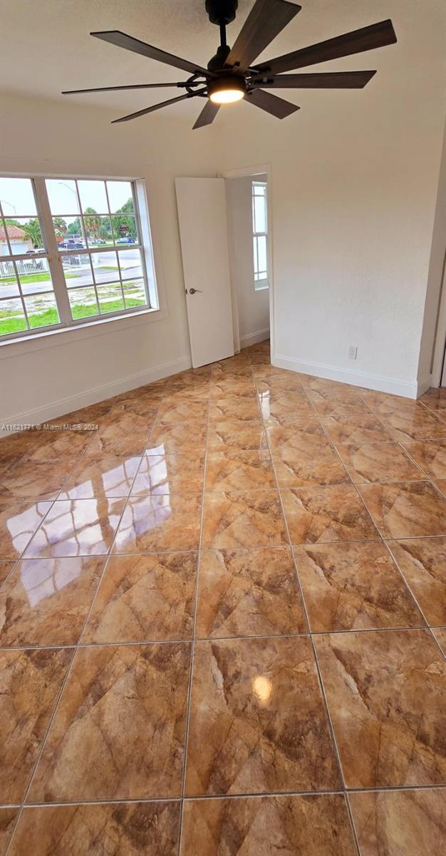 unfurnished room with plenty of natural light and ceiling fan