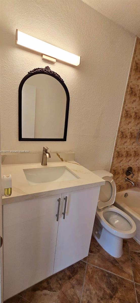 full bathroom with vanity,  shower combination, and toilet