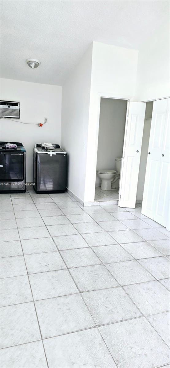 interior space featuring a wall mounted AC and a textured ceiling