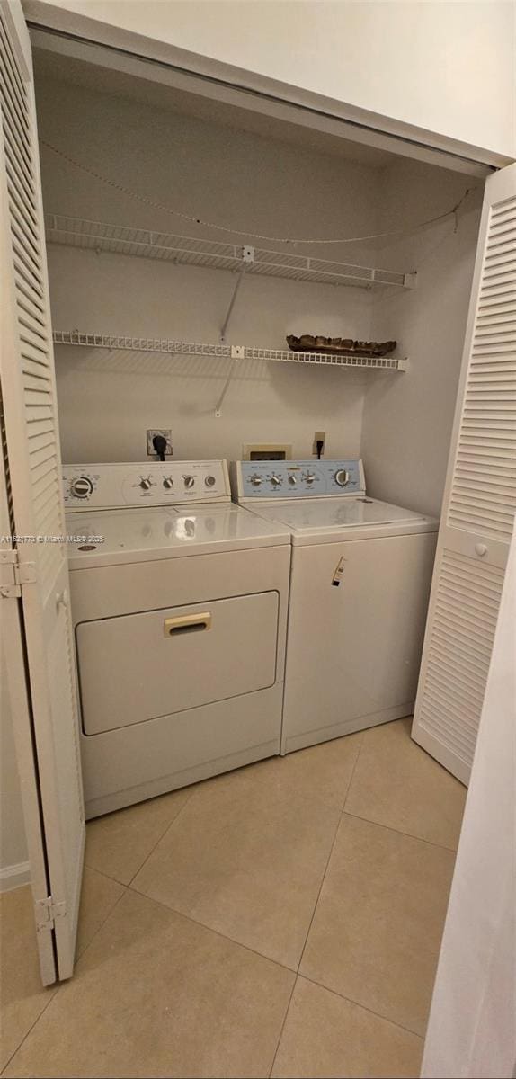 washroom with washing machine and dryer and light tile patterned floors