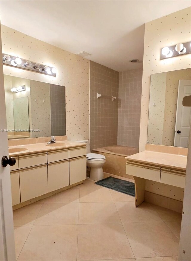 bathroom with toilet, vanity, and tile patterned flooring