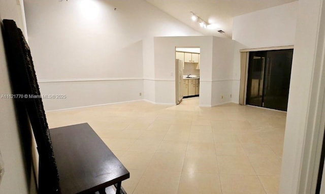 tiled empty room with vaulted ceiling