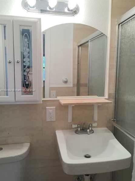 6707 N Kendall Dr Unit 115, Pinecrest, FL 33156 - bathroom featuring toilet, a shower with door, and a sink