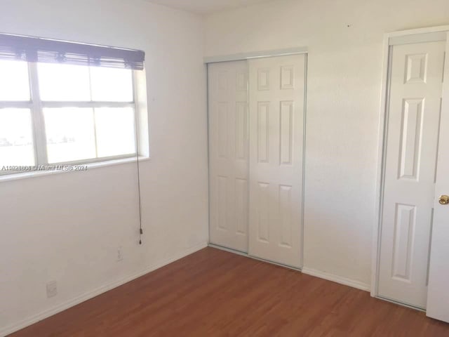 6707 N Kendall Dr Unit 115, Pinecrest, FL 33156 - unfurnished bedroom featuring a closet, wood finished floors, and baseboards