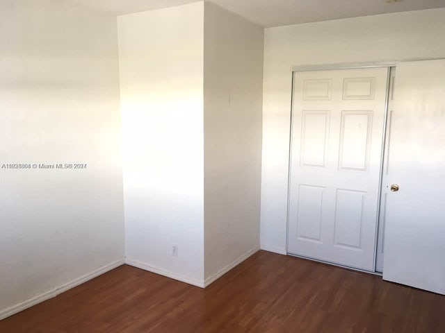 6707 N Kendall Dr Unit 115, Pinecrest, FL 33156 - unfurnished bedroom with dark wood-style floors, baseboards, and a closet