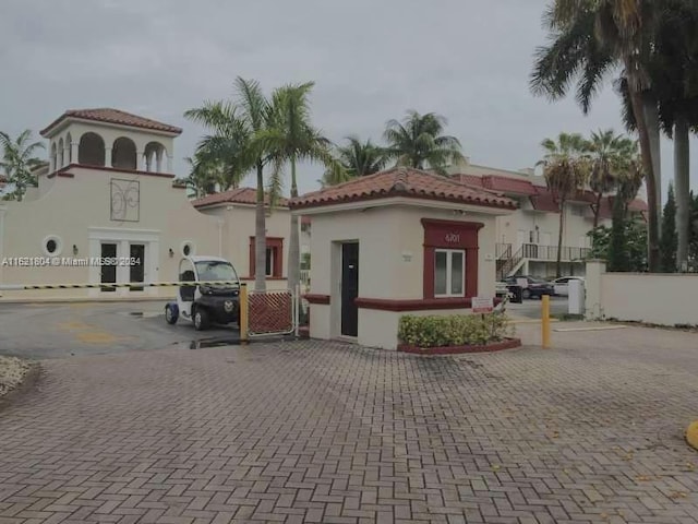 6707 N Kendall Dr Unit 115, Pinecrest, FL 33156 - view of front facade with a tile roof, fence, and stucco siding