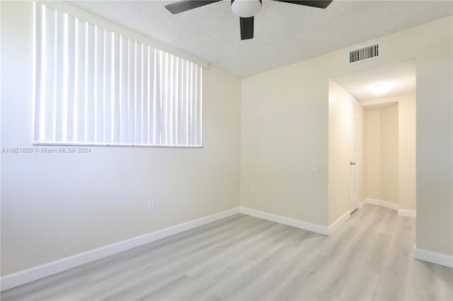 unfurnished room with light hardwood / wood-style floors and a textured ceiling