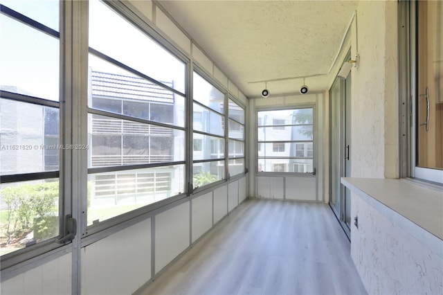 unfurnished sunroom with rail lighting