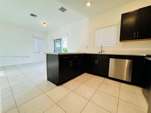 kitchen with light tile patterned flooring, kitchen peninsula, sink, and stainless steel dishwasher