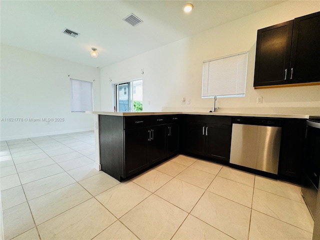 kitchen featuring stainless steel dishwasher, kitchen peninsula, sink, and light tile patterned floors