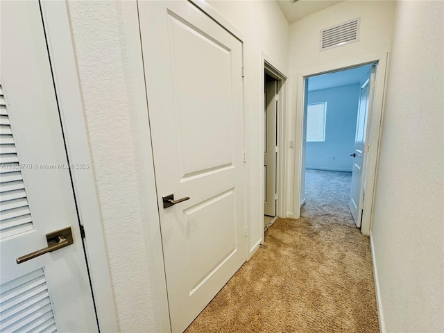 hall with light colored carpet