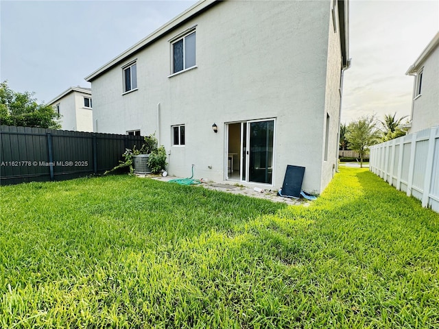 rear view of property featuring cooling unit and a yard