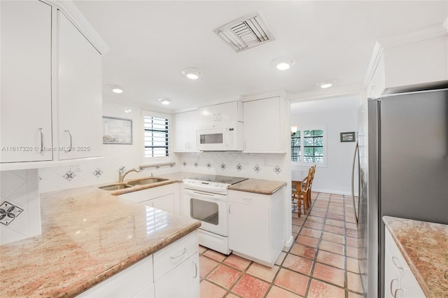 kitchen with white appliances, white cabinetry, a wealth of natural light, and sink