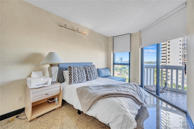 bedroom with access to exterior and a textured ceiling