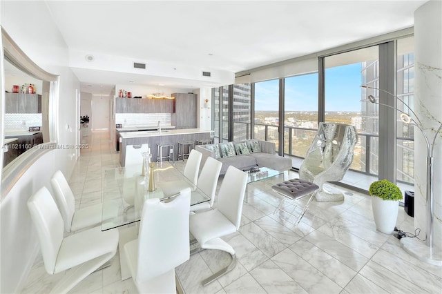 dining room featuring sink and a wall of windows