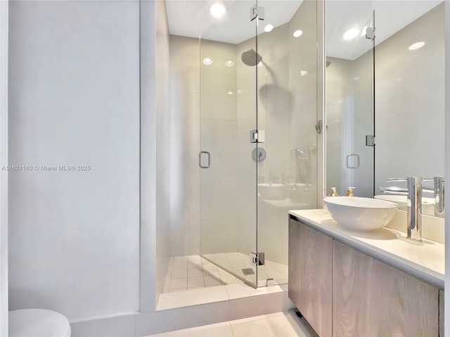 bathroom with tile patterned flooring, vanity, and a shower with shower door