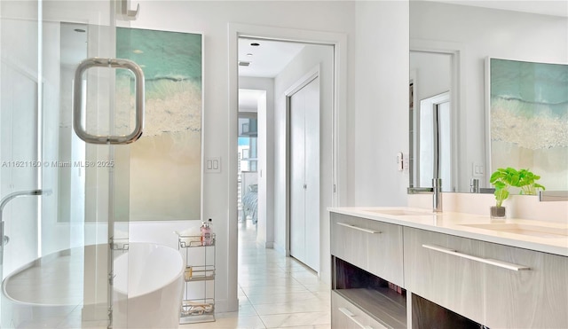 bathroom with tile patterned flooring, a bathing tub, and vanity