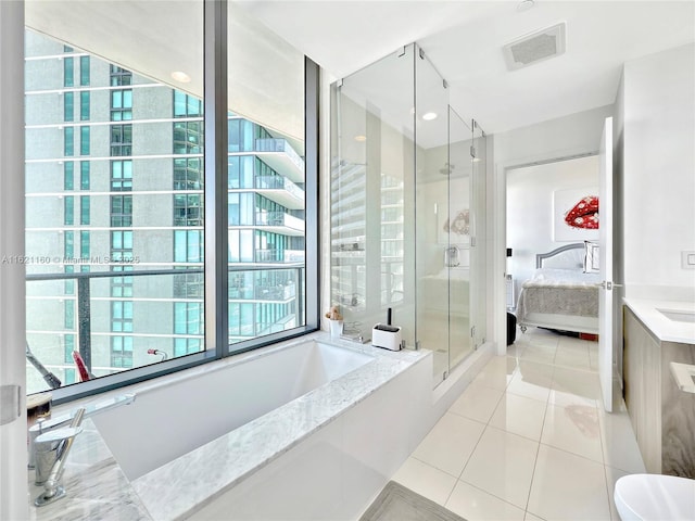 bathroom with tile patterned flooring, vanity, and separate shower and tub