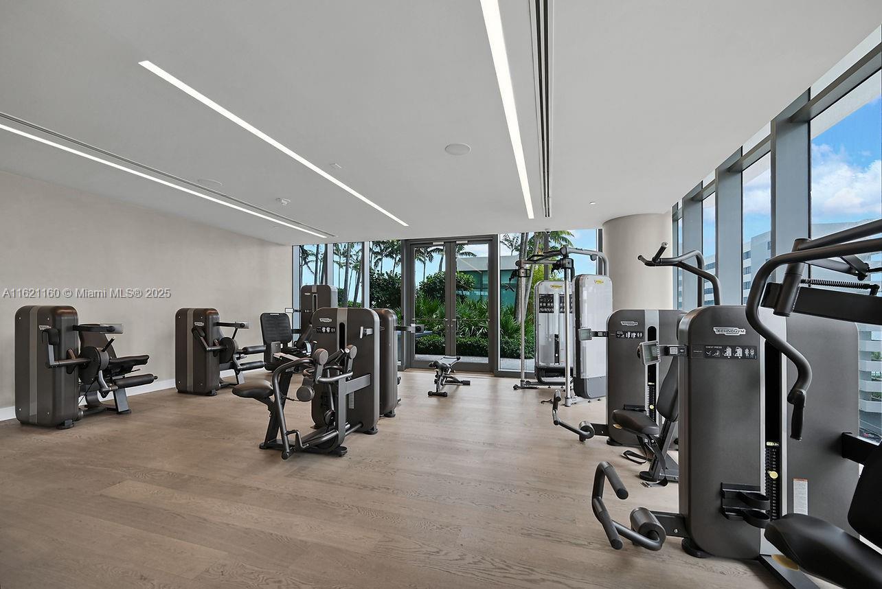 gym featuring floor to ceiling windows and light hardwood / wood-style floors