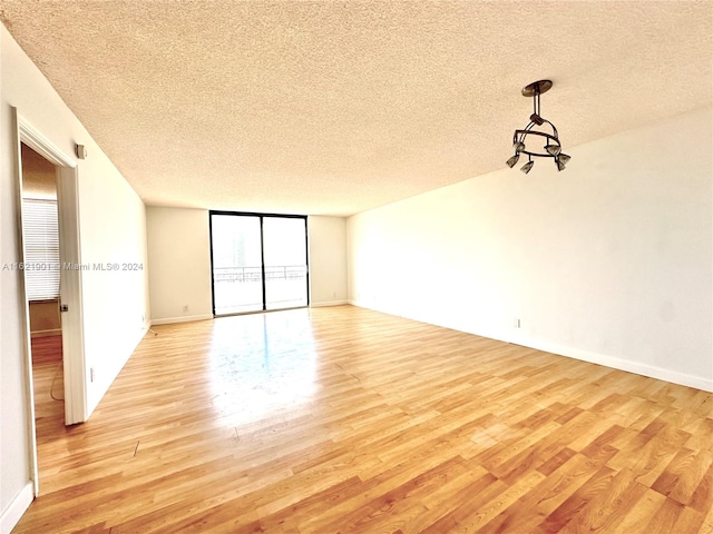 unfurnished room featuring a textured ceiling and light hardwood / wood-style flooring