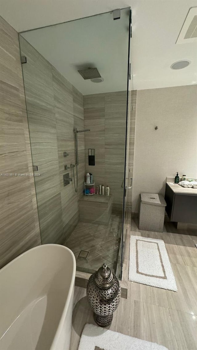 bathroom with independent shower and bath and vanity