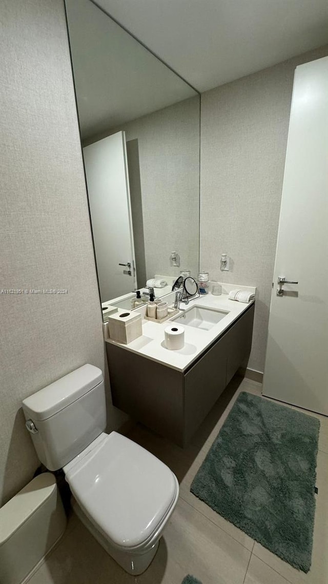 bathroom featuring vanity, toilet, and tile patterned flooring