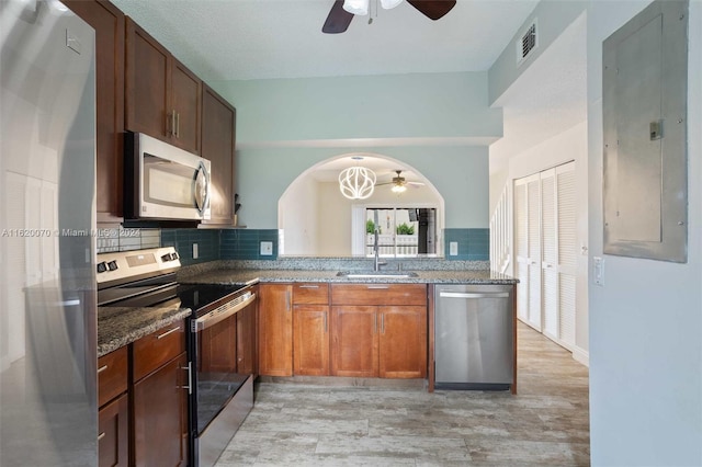 kitchen with decorative backsplash, sink, ceiling fan, and stainless steel appliances