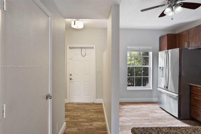 kitchen featuring stainless steel fridge with ice dispenser, light hardwood / wood-style floors, a textured ceiling, and ceiling fan