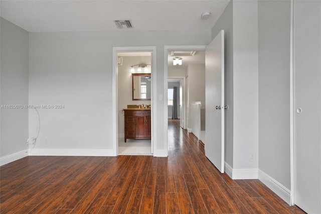 hallway featuring dark wood-type flooring and a textured ceiling