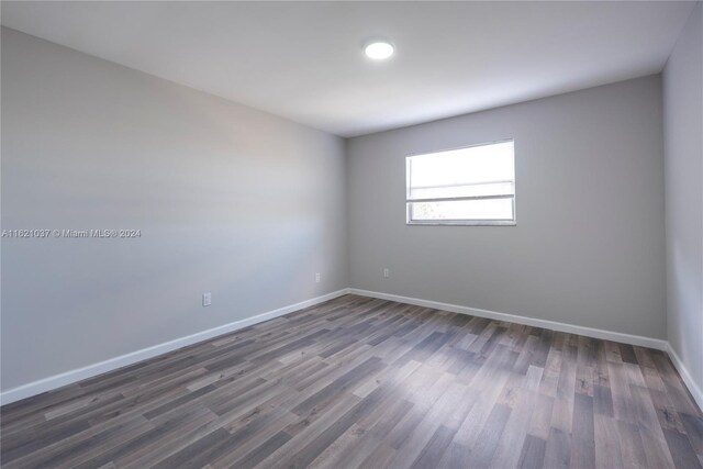 unfurnished room featuring dark wood-type flooring