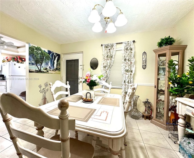 dining space featuring light tile patterned flooring, a textured ceiling, and an inviting chandelier