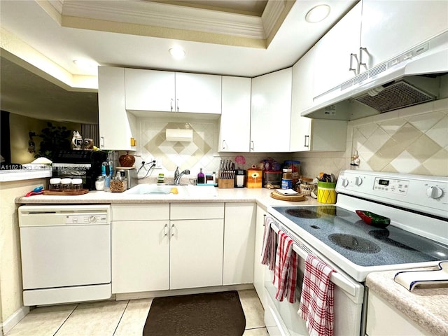 kitchen featuring decorative backsplash, a tray ceiling, white appliances, and ornamental molding