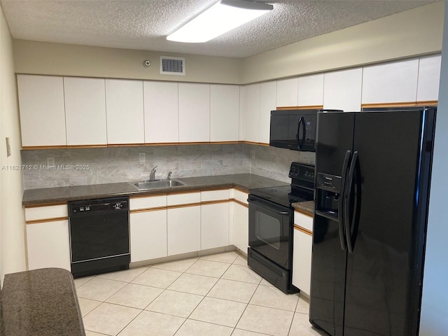 kitchen featuring tasteful backsplash, a textured ceiling, sink, black appliances, and white cabinets