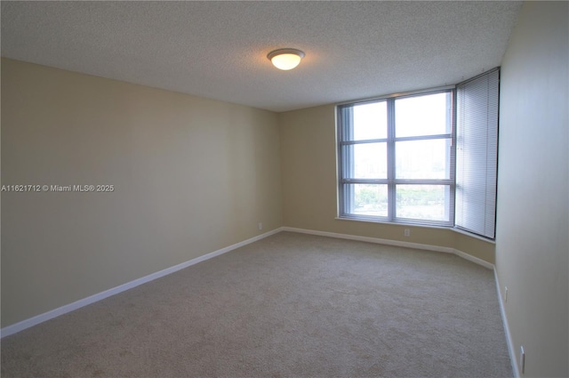 carpeted spare room with a textured ceiling