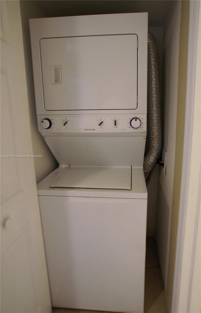 clothes washing area featuring stacked washer and clothes dryer