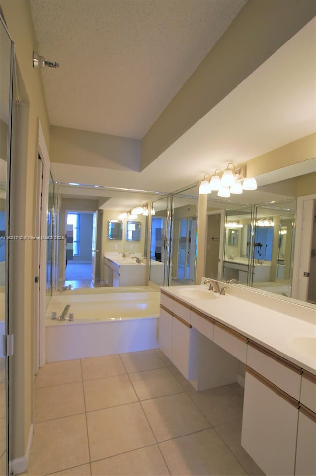 bathroom featuring tile patterned flooring, a bath, and vanity