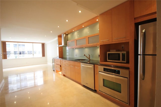 kitchen featuring light tile patterned floors, stainless steel appliances, wall chimney exhaust hood, and sink