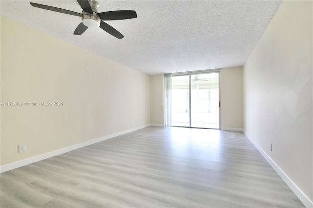 unfurnished room featuring expansive windows, a textured ceiling, and light hardwood / wood-style flooring