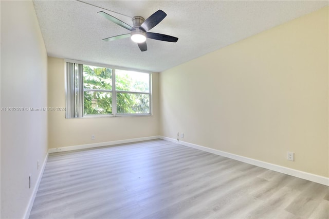 unfurnished room featuring ceiling fan, a textured ceiling, and light wood-type flooring