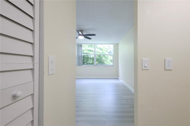 corridor featuring wood-type flooring and a textured ceiling