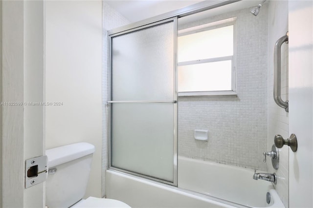 bathroom with shower / bath combination with glass door and toilet