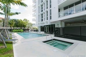 view of pool with a patio area and a hot tub